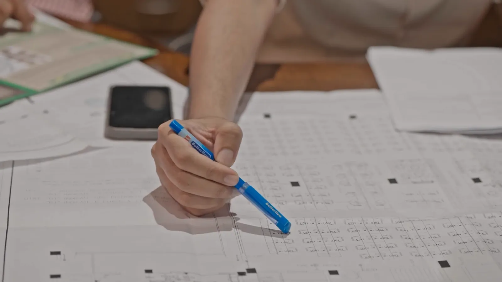 A hand marking up a floor plan